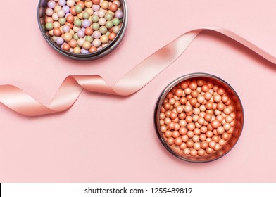 Ball pearl blush, face powder and pink ribbon on a pastel pink background top view Flat Lay with copy space. Various cosmetic products, Makeup Accessories. 