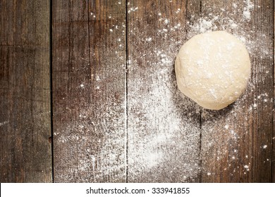 Ball Of Pizza Dough On A Rustic Wooden Background With Dusting Of Flour