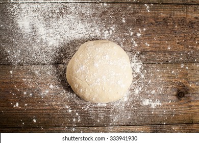 Ball Of Pizza Dough On A Rustic Wooden Background With Dusting Of Flour