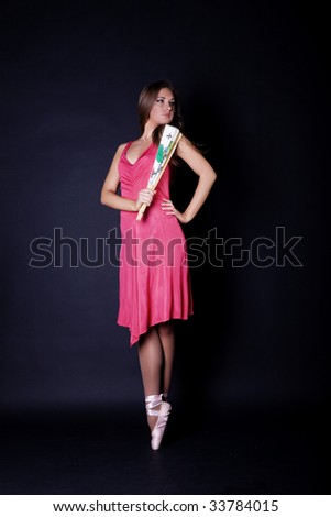 Ballerina in ballet shoes with fan in hand