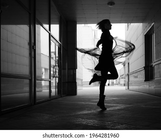 Ballerina Dances To The Music In The City. Silhouette Of Girl Dancing Between Walls. 