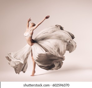 Ballerina Dancing In Flowing Dress  In Studio