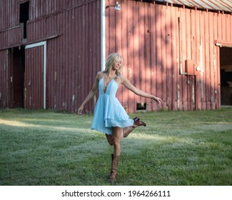 Ballerina Dancing in front of a Red Barn