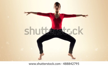 Ballerina dancing over ocher background