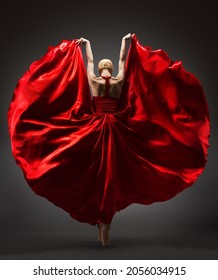 Ballerina Dancing in Red Flying Dress Rear Back Side View. Graceful Woman Ballet Performer in Flamenco Skirt. Expressive Passion Dance in Motion over Dark Background