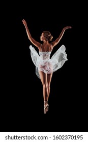 ballerina dancing in studio on a black background. dancer in motion with his back. isolated. young ballet dancer        