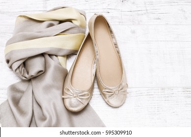 Ballerina flats and soft scarf on white wooden background, copy space.