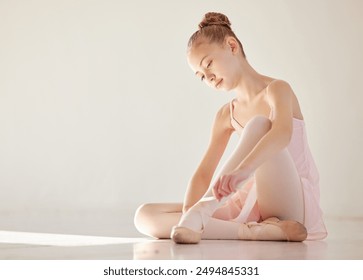 Ballerina, girl and tying shoes on floor for practice, education and learning dance in studio. Student, ballet and tie footwear ribbon on ground for creative talent, art and performance academy - Powered by Shutterstock