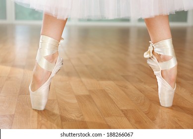 Ballerina legs in pointes in dancing hall