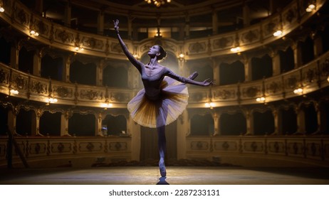 of Ballerina in Pointe Shoes and White Tutu Dancing and Rehearsing on Classic Theatre Stage with Dramatic Lighting. Graceful Classical Ballet Female Dancer Performing a Choreography - Powered by Shutterstock