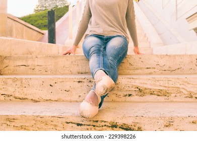 Ballerina sitting on step in shoes - Powered by Shutterstock