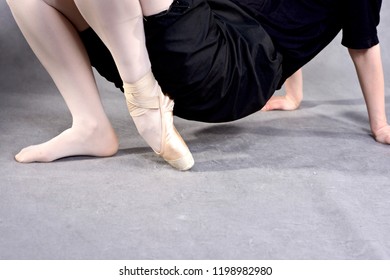 Ballerina warming up feet before the rehearsal. Classical school of ballet.