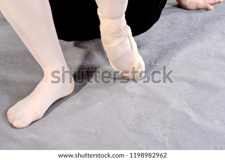 Ballerina warming up feet before the rehearsal. Classical school of ballet.