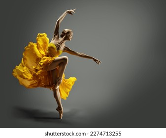 Ballerina con traje de chile amarillo bailando sobre fondo gris. Bailarina de ballet saltando al aire en vestido de seda. Mujer elegante bailarina moderna actuando en la falda voladora