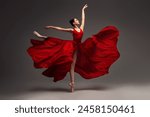 Ballerina. Young graceful woman ballet dancer, dressed in professional outfit, shoes and red weightless skirt is demonstrating dancing skill. Beauty of classic ballet