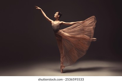 Ballerina. Young graceful woman ballet dancer, dressed in professional outfit, shoes and beige weightless skirt is demonstrating dancing skill. Beauty of classic ballet.