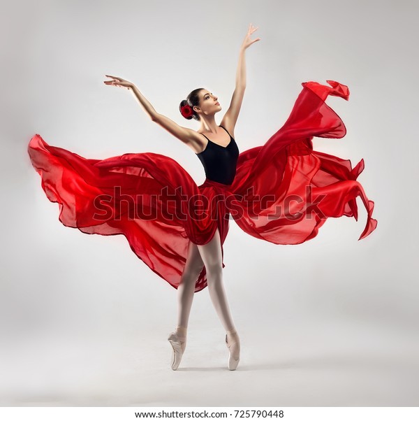 Ballerina. Young graceful woman\
ballet dancer, dressed in professional outfit, shoes and red\
weightless skirt is demonstrating dancing skill. Beauty of classic\
ballet.