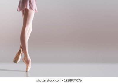 Ballerina's feet in pointe shoes standing isolated on a white background - Powered by Shutterstock