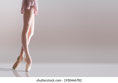 Ballerina's feet in pointe shoes standing isolated on a white background
