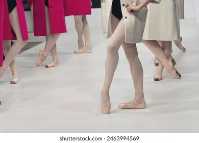 Ballerinas in pointe shoes perform a dance at a fashion show. Fashion industry - Powered by Shutterstock