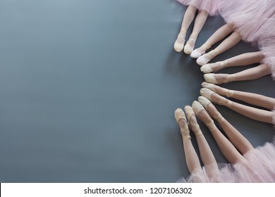 Ballet background. Little ballerinas legs in pointe shoes on floor, top view, copy space