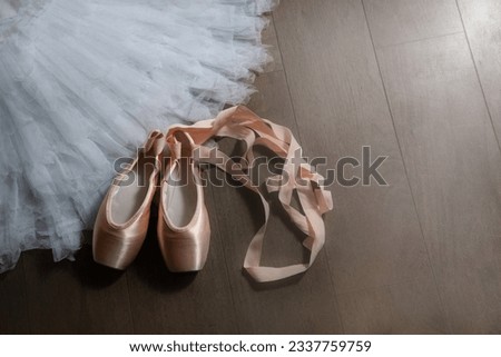Ballet beige pointe shoes with a ribbon on the tutu skirt. Ballerina set. The concept of dance, spring, ballet school, ballerinas clothes and things.
