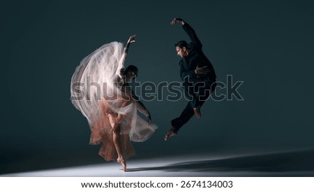 Ballet couple moving in synchronized dramatic jump with flowing dress motion. Concept of energy, passion, performing arts, fluid choreography, emotional harmony and cultural expression.