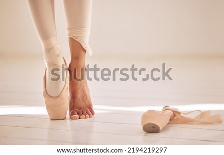 Ballet, dance and toe shoes with a ballerina or creative artist standing on a floor of a dancing studio. Performer, training and practice with a woman in rehearsal for a recital, performance or show