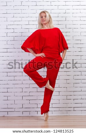 Ballet dancer (ballerina) dancing in a red suit and pointe