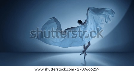 Ballet dancer lifting large white fabric arc on cool blue spotlight. Concept of modern campaign visuals, clean stage design, expressive dance photography.