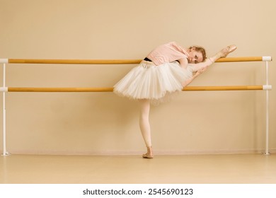 A ballet dancer rests on the barre, holding a stretch with her leg raised, displaying flexibility and relaxation. - Powered by Shutterstock