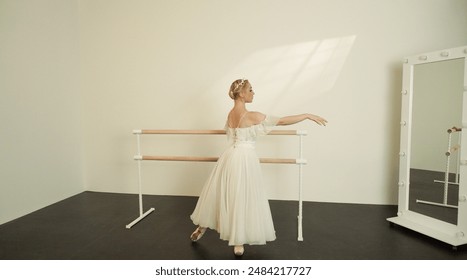 Ballet Dancer in White Dress Practicing at Barre in Sunlit Studio - Powered by Shutterstock