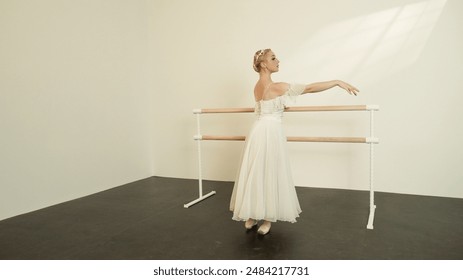 Ballet Dancer in White Dress Practicing at Barre in Sunlit Studio - Powered by Shutterstock