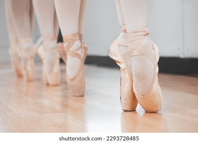 Ballet dancers may make it look easy, but we all know its anything but. Shot of a group of ballerina dancers practicing a routine in their pointe shoes. - Powered by Shutterstock