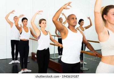Ballet dancers stands near the ballet barre at the ballet hall. - Powered by Shutterstock