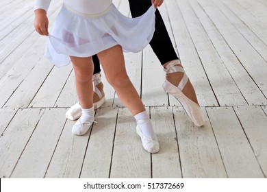 Ballet instructor directs little cute ballerina during dance practice