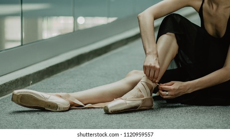 ballerina preparing shoes