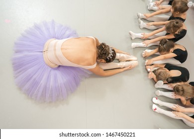 Ballet School Teacher In A Lesson Shows Children A Stretch