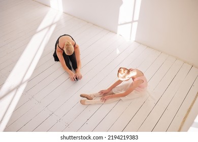 Ballet Stretching, Dance Student And Teacher In Studio For Theatre Performance, Dancing Education And Creative Art Learning From Above. Young Girl Training With Mentor For Dancer Practice And Class