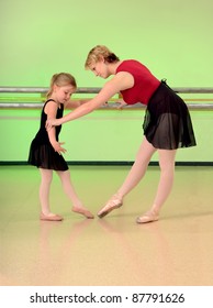 A Ballet Teacher Helps A Girl Dance Student With Her Lesson