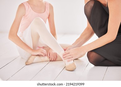 Ballet Teacher, Student And Dance Injury In Class With Girl Dancer And Helpful Instructor Touching Ankle, Feet And Shoe At A Studio. Ballerina Child Performer Getting A Foot Massage During Training.