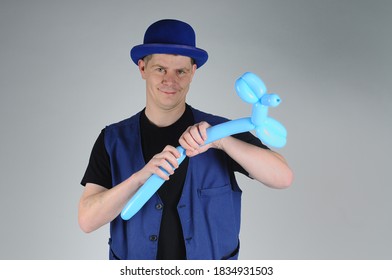 Balloon Artist Creating A Blue Dog Balloon