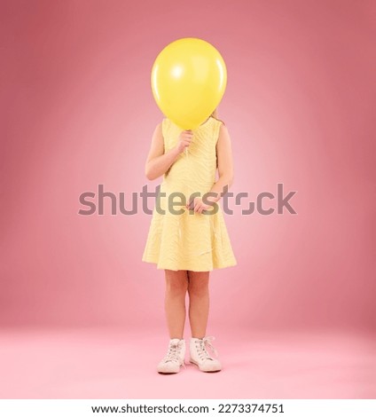 Balloon cover face, girl and child in studio isolated on a pink background mockup. Children, birthday party and celebration event with young shy kid hiding with yellow air ballons and inflatable.