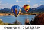 Balloon Festival with hot air balloons with Texas design hovering over a blue lake with blue skies and a mountain range in the background.