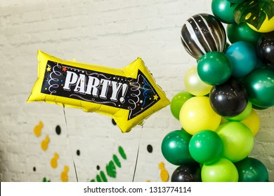 Balloon in the form of a pointer with the words "party". The ball indicates the decorated area for recreation and dance with colorful balloons, garlands and various decorations