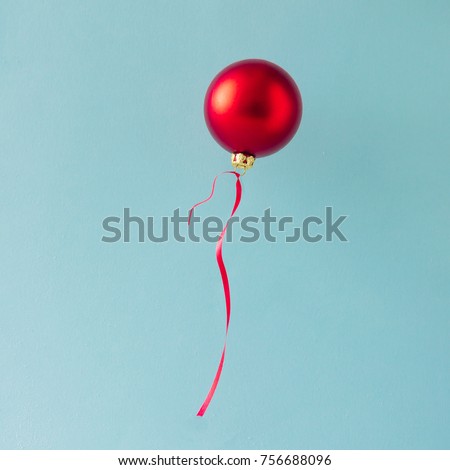 Balloon made of Red Christmas bauble decoration on blue background. Minimal Christmas concept.