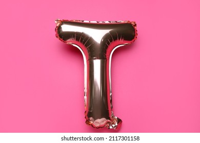 Balloon in shape of letter T on pink background