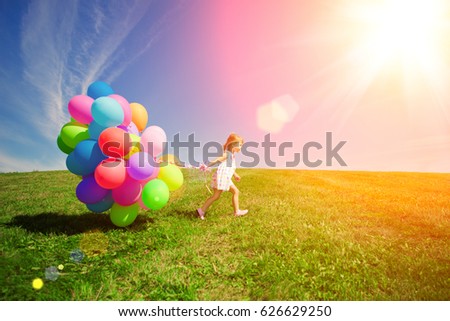 Balloons for the birthday against the background of the sky and green grass. Summer fun party. Summertime holiday.