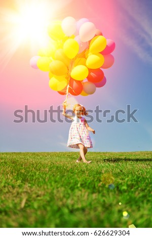 Balloons for the birthday against the background of the sky and green grass. Summer fun party. Summertime holiday.