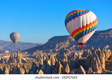Balloons flying over rock landscape at Cappadocia Turkey.